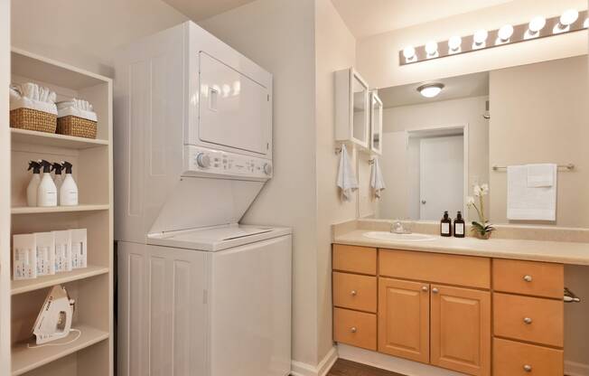 a bathroom with a washer and dryer and a sink and a mirror at Vineyard Terrace Apartments, Napa, 94558