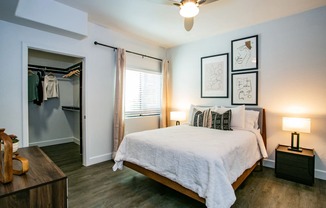 A bedroom with a bed, nightstand, and a ceiling fan.