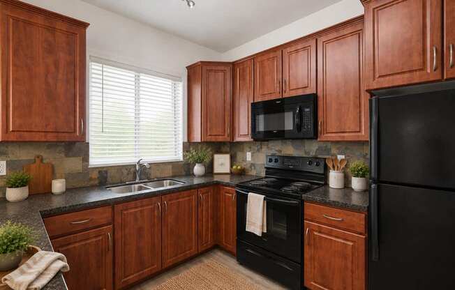 A kitchen with wooden cabinets and black appliances.