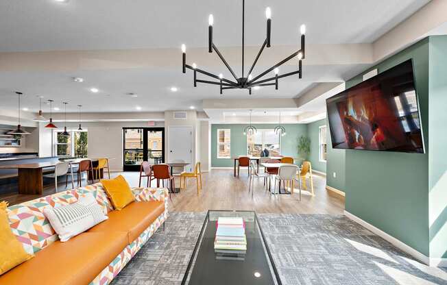 A living room with a couch, chairs, and a television.