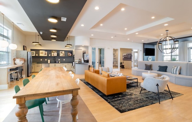 a living room and dining room with a large wooden table in the middle of the room