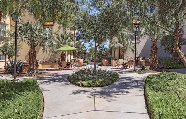 a courtyard with trees and tables and chairs