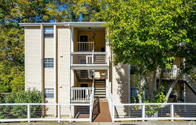 a white apartment building with stairs and trees