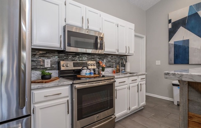 Sterling Park apartments kitchen with white cabinets and stainless appliances