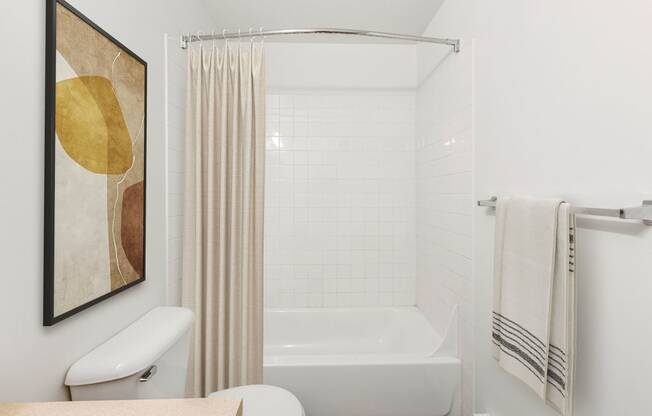 a white bathroom with a tub and a shower curtain
