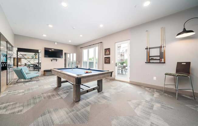 A room with a pool table and a chair.