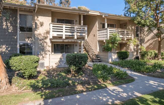 an apartment building with a sidewalk in front of it at Alosta Place, Azusa, CA