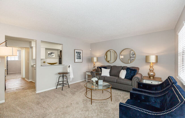 Kitchen with Breakfast Bar Opening Up to Carpeted Living Room