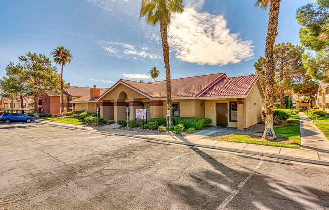 a building with a parking lot and palm trees