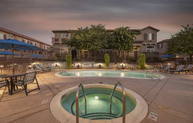 Dusk image of pool and jacuzzi with lounge seating