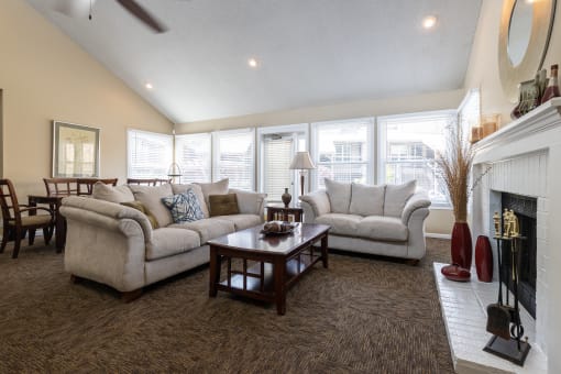 A cozy clubhouse living room with plush seating and a fireplace.