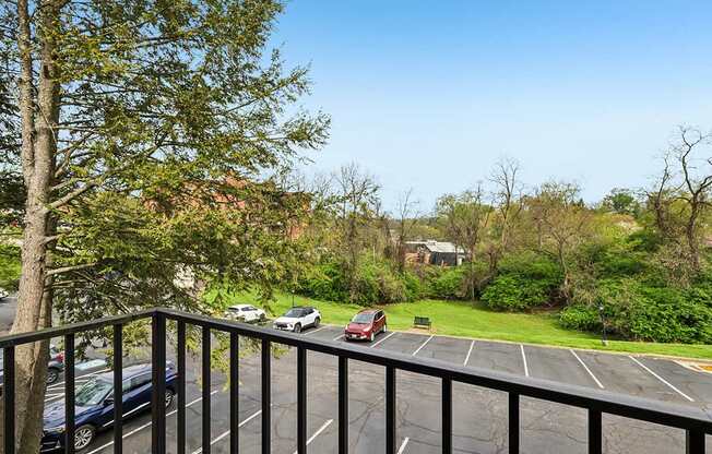 A parking lot with cars and a tree in the foreground.