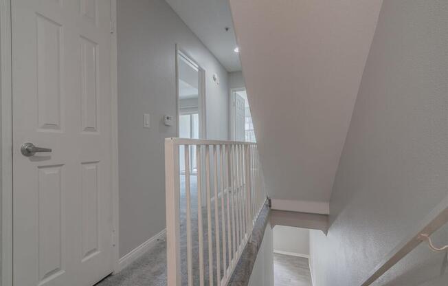the landing of a staircase in a home with a white door at Warner Center Townhomes, Canoga Park California