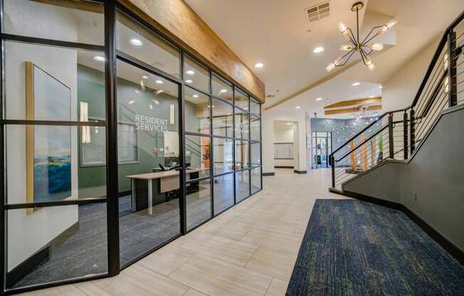 a large lobby with glass doors and a staircase