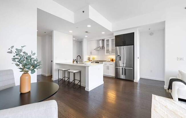 A modern kitchen with a black table and white cabinets.