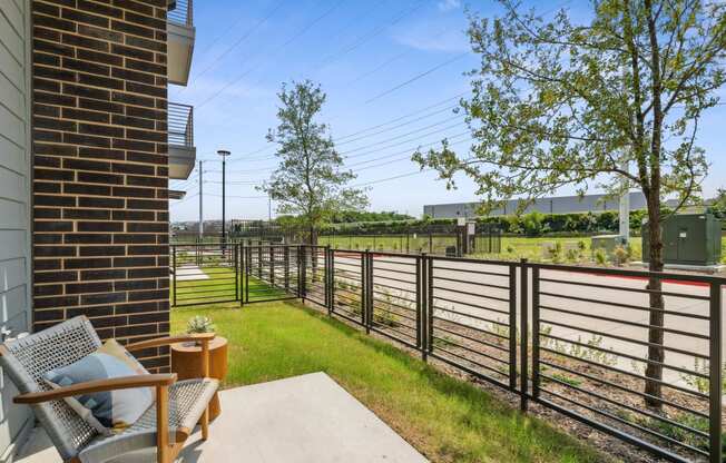 a patio with chairs and a fence and a train track