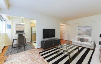 living area with sofa, coffee table, hardwood floors and view of dining area at sherry hall apartments in washington dc