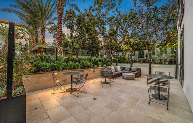 Outdoor terrace with cozy seating, lush landscaping, and intimate tables for morning coffee or evening unwinds