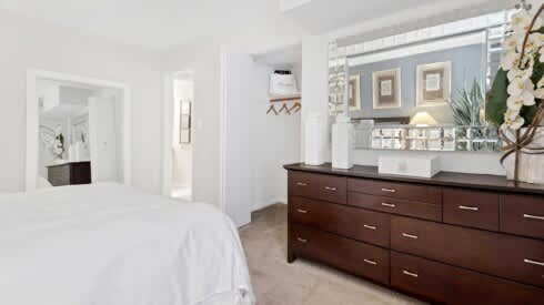 a bedroom with a bed and a dresser and a mirror