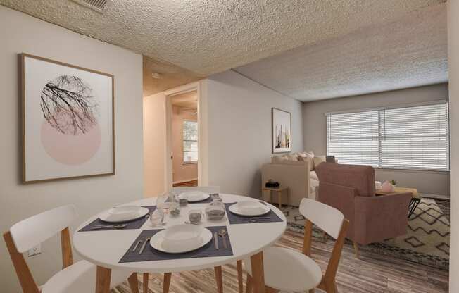 a dining area with a table and chairs and a living room in the background