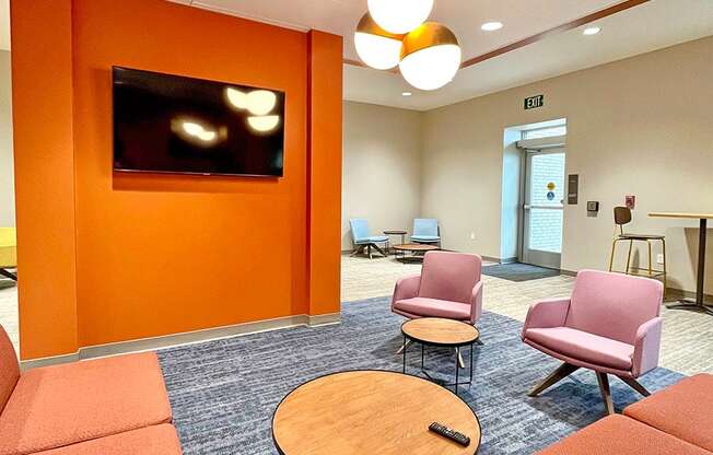 clubroom/resident lounge with sofa, two arm chairs, coffee table and television at The Residences at Delmar DivINe, St Louis, MO