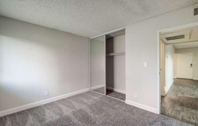 an empty living room with a closet in the corner