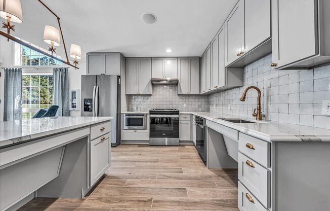 a large kitchen with white cabinets and stainless steel appliances
