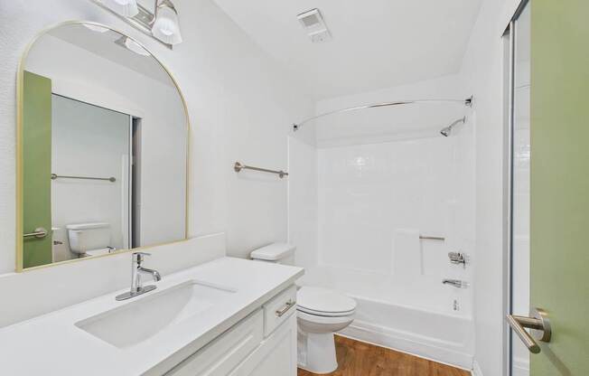 A bathroom with a sink, toilet, and bathtub.