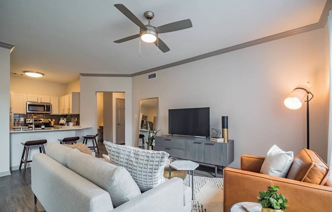 a living room with a couch and a ceiling fanat Creekside at Legacy, TX 75024