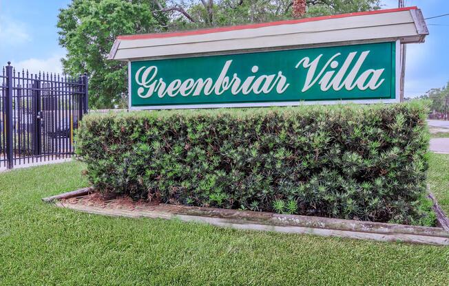 a sign in front of green grass