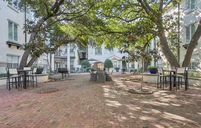 A courtyard with a brick floor and trees.