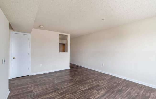 an empty living room with white walls and wood floors