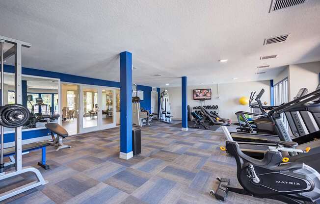 A gym with a variety of equipment including a treadmill.