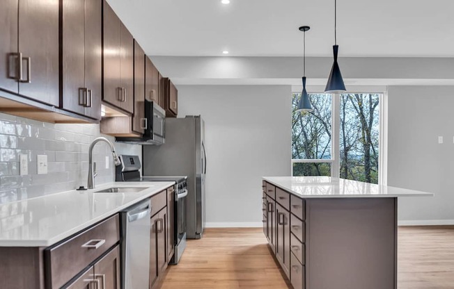 A modern kitchen with dark wood cabinets and stainless steel appliances.