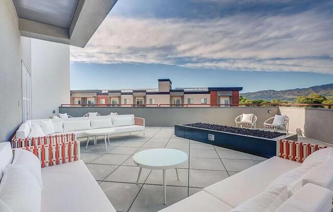 A white couch is on a patio with a table and chairs.