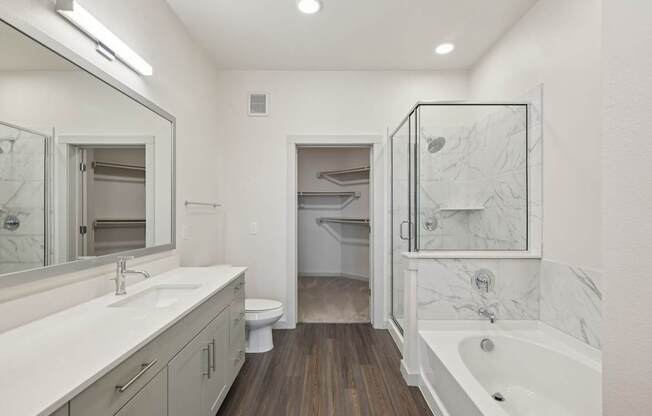 A bathroom with a white tub, sink, and toilet.