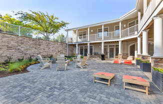 a patio with tables and chairs in front of a house at Copper and Quarry Village, Pikesville, MD