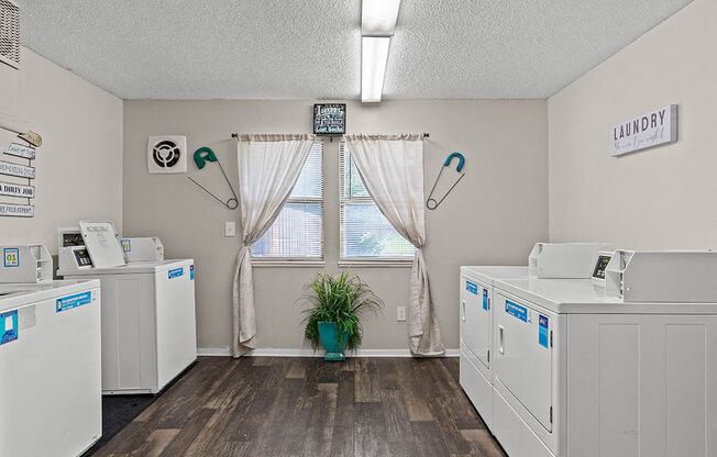 a laundry room with washes and dryers and a window