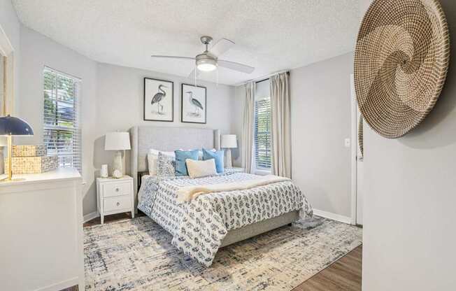 A bedroom with a large bed and a ceiling fan.