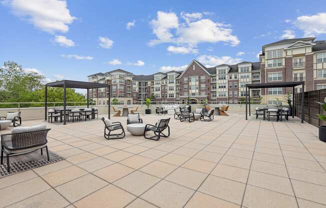 A patio with a table and chairs is surrounded by apartment buildings.