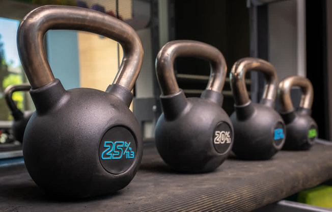 A set of kettlebells with the numbers 25, 20, and 15 written on them.