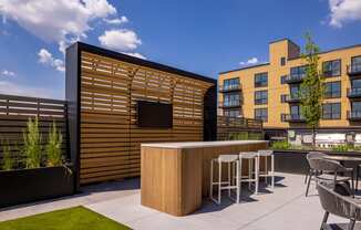 a bar area on the roof of a building with a blue sky in the background