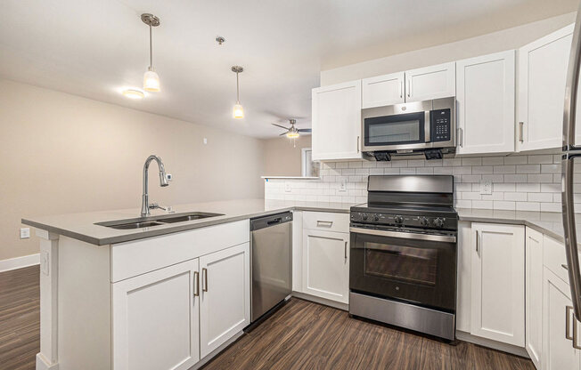 a kitchen with white cabinets and stainless steel appliances