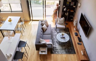 A living room with a grey couch, a white table, and a television.