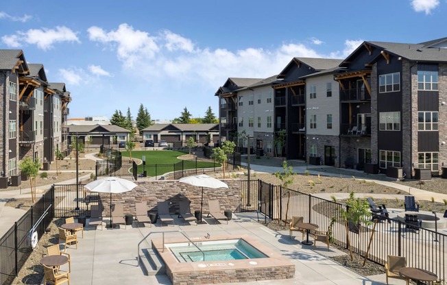 A large outdoor swimming pool surrounded by a fence and chairs.