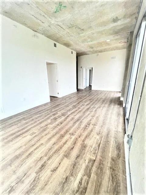 a empty living room with a hard wood floor