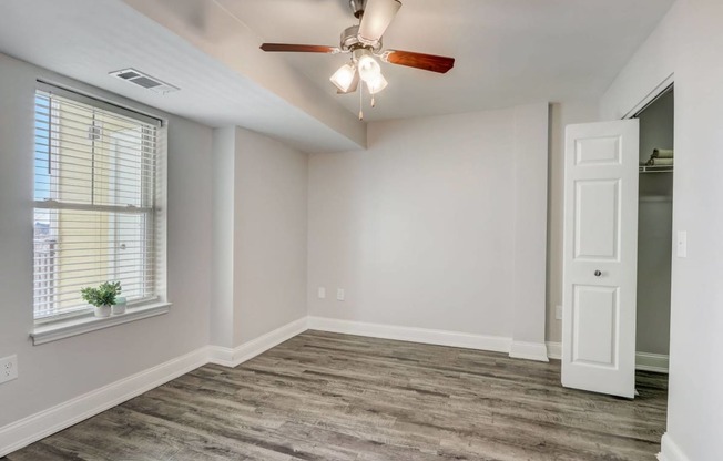 Bedroom with faux hardwood floors, white trim and neutral walls.  Ceiling fan and two windows that allow an abundance of natural light.