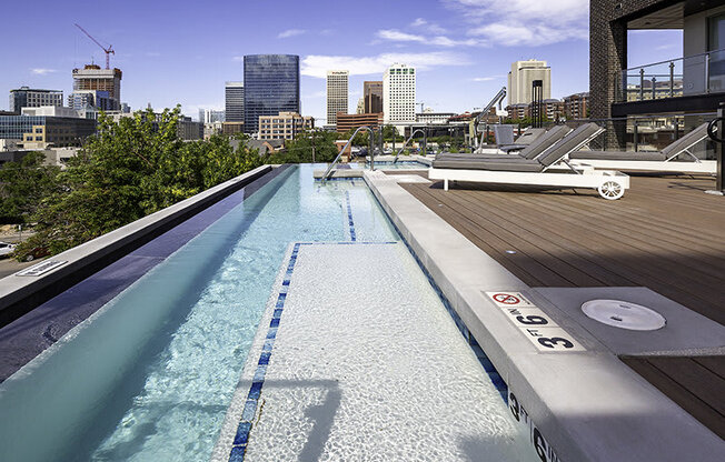 a pool on a rooftop with a city in the background