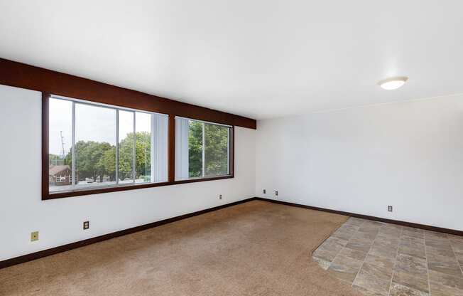 a living room with white walls and a large window