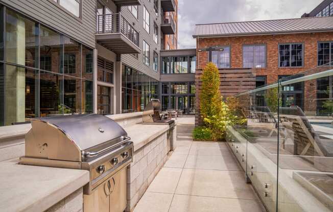 an outdoor patio with a grill and a building